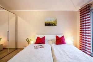 a bedroom with two beds with red pillows at Bauernhof Lafrenz in Fehmarn