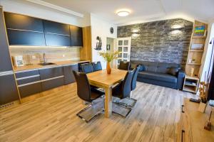Il comprend une cuisine et une salle à manger avec une table et des chaises en bois. dans l'établissement Apartment 10 in Villa Petrac, à Rab