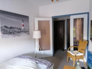 a bedroom with a bed and a lighthouse picture on the wall at Hotel Möven-Kieker in Friedrichskoog