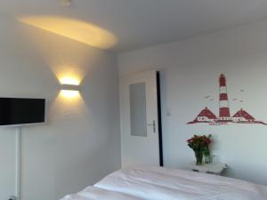 フリードリッヒシュコオクにあるHotel Möven-Kiekerのベッドルーム1室(ベッド1台、壁に照明付)