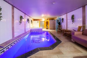 a swimming pool with purple lighting in a house at Thai Time Wellness in Antwerp
