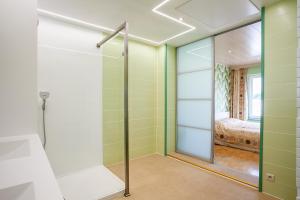 a walk in shower with a glass door in a bedroom at Thai Time Wellness in Antwerp