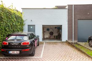 a black car parked in front of a garage at Thai Time Wellness in Antwerp