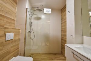 a bathroom with a shower with a toilet and a sink at Strzelnica Hotel i Restauracja in Starogard Gdański