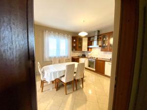 uma cozinha com uma mesa e cadeiras brancas num quarto em Apartment Marcella 1 em Ljubac