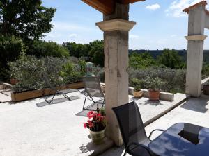 un patio con due sedie e un tavolo con fiori di Gîtes Lou Limbert Plateau de Valensole a Valensole