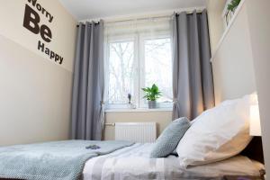 Schlafzimmer mit einem Bett und einem Fenster mit Vorhängen in der Unterkunft Luxus Apartament Wzgorze in Gdynia