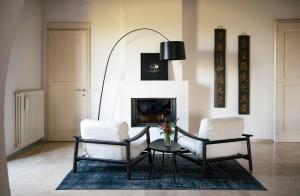 sala de estar con 2 sillas, mesa y chimenea en canonica 43, en Colle Val D'Elsa