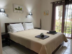 ein Schlafzimmer mit einem Bett mit zwei Hüten darauf in der Unterkunft Alexander Apartments in Roda