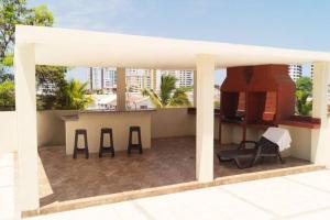 a patio with a table and chairs on a roof at Chipipe Salinas Beachfront Apartment w Parking in Salinas