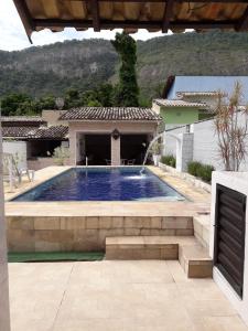- une piscine dans une cour avec une maison dans l'établissement Casa c wifi e piscina próx a praia e a Alto Mourão, à Maricá