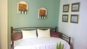- une chambre avec un lit doté de draps blancs et 2 fenêtres dans l'établissement ESTIA HOLIDAY HOUSE, à Vathi