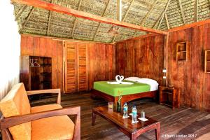 a bedroom with a green bed and a table at Nicky Amazon Lodge in Marian