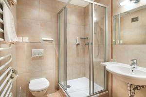 un bagno con doccia, WC e lavandino di Hotel Stockerwirt a Ramsau am Dachstein