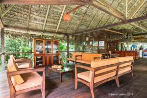 sala de estar con sillas, mesas y techo en Nicky Amazon Lodge, en Marian