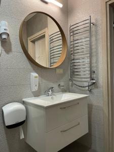 a bathroom with a white sink and a mirror at Sweet home30 in Vilnius