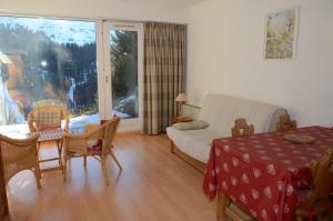 ein Wohnzimmer mit einem Sofa, einem Tisch und Stühlen in der Unterkunft Appartement Flaine Forêt in Flaine