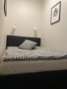 a bed with a black headboard and a pillow on it at Sweet home30 in Vilnius