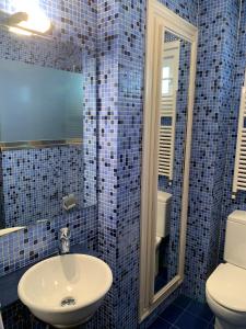 baño de azulejos azules con lavabo y aseo en Apartxibi, en Bermeo
