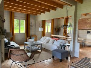 sala de estar con sofá blanco y mesa en Gîte des Etangs, en Glanville