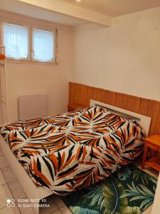 a bed with a colorful comforter in a bedroom at Le Crotoy Plage Baie de somme Appt l'Aigrette in Le Crotoy