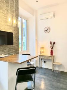 a dining room with a table and a clock on the wall at Studio Mezzanine Rue Pieta in Menton