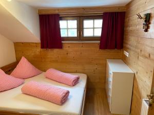 two beds in a small room with red curtains at Der Waidachhof Zillertal in Hainzenberg