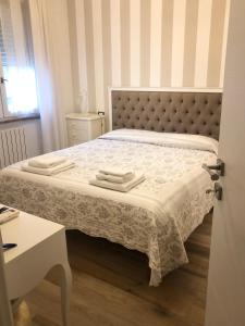 1 dormitorio con 1 cama con 2 toallas en La Rosa Bianca, en Rozzano