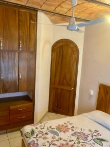 - une chambre avec un lit et une armoire en bois dans l'établissement Casa Balam, à Rincon de Guayabitos