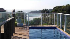 einen Pool auf einer Terrasse mit Meerblick in der Unterkunft Pousada Las Piedras in Praia do Rosa