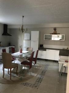 a kitchen with a dining room table and chairs at 13 Rue du Perré Maison de vacances in La Membrolle-sur-Choisille