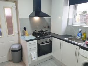 uma pequena cozinha com um fogão e um lavatório em South Shield's Diamond 3 Bedroom House Sleeps 6 Guests em South Shields