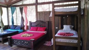ドラケにあるOur Home Corcovadoのベッドルーム1室(赤いシーツを使用した二段ベッド2組付)