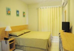 una piccola camera con letto e televisore di Hotel Golden Dolphin com café da manhã! Piscinas 24h a Caldas Novas Altre 74 foto