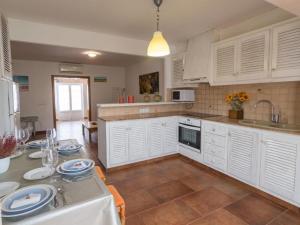 a kitchen with white cabinets and a table with plates on it at LEIDA - Relax y privacidad in Cala Blanca