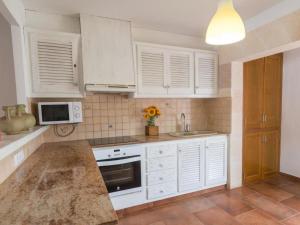 a kitchen with white cabinets and a counter top at LEIDA - Relax y privacidad in Cala Blanca