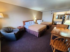 a hotel room with two beds and a chair at Berlin Heritage Inn in Berlin