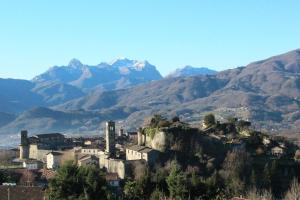 una ciudad en una colina con montañas en el fondo en IL CASALE di ROLANDO, en Castiglione di Garfagnana