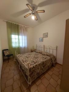 una camera con letto e ventilatore a soffitto di Villetta Alessia a Marina di Mancaversa