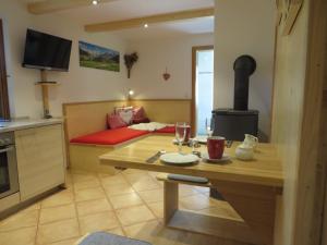ein Wohnzimmer mit einem Tisch und einem Herd in der Unterkunft Landhaus Familie Doll Ferienwohnung Emerde in Bichl
