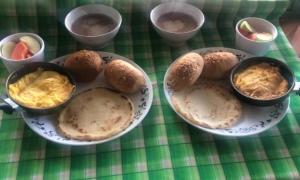 a table with two plates of food and bowls of food at Finca Hotel el Rocio in Circasia