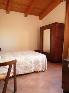 - une chambre avec un lit et un miroir dans l'établissement Casale Nel Verde, à San Vito Chietino