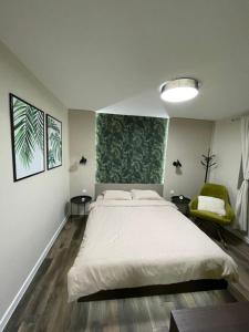 ein Schlafzimmer mit einem großen weißen Bett und einem Stuhl in der Unterkunft Apartmani Jović in Kuršumlija