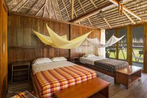 a bedroom with two beds and a hammock in it at Nicky Amazon Lodge in Marian