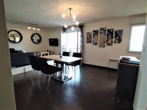 a dining room and living room with a table and chairs at Cocoon'Inn Blagnac in Blagnac