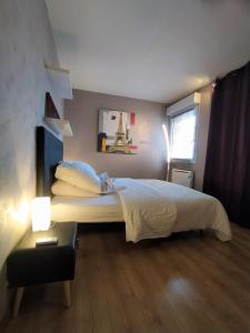 A bed or beds in a room at Cocoon'Inn Blagnac