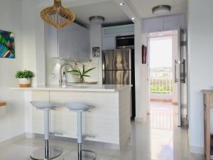 a kitchen with a white counter and stools at Waterfront studio at Fajardo, Puerto Rico in Fajardo