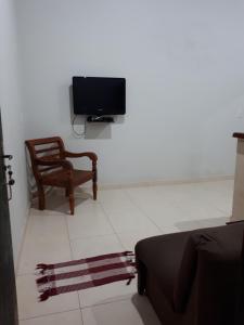 a living room with a tv and a chair at Loft Pireneus 2 in Pirenópolis