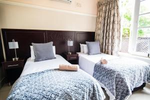 A bed or beds in a room at New England Guest House by Ilawu