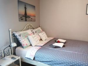 a small bedroom with a bed with pillows and a lamp at Apartments Sven-Marino in Poreč